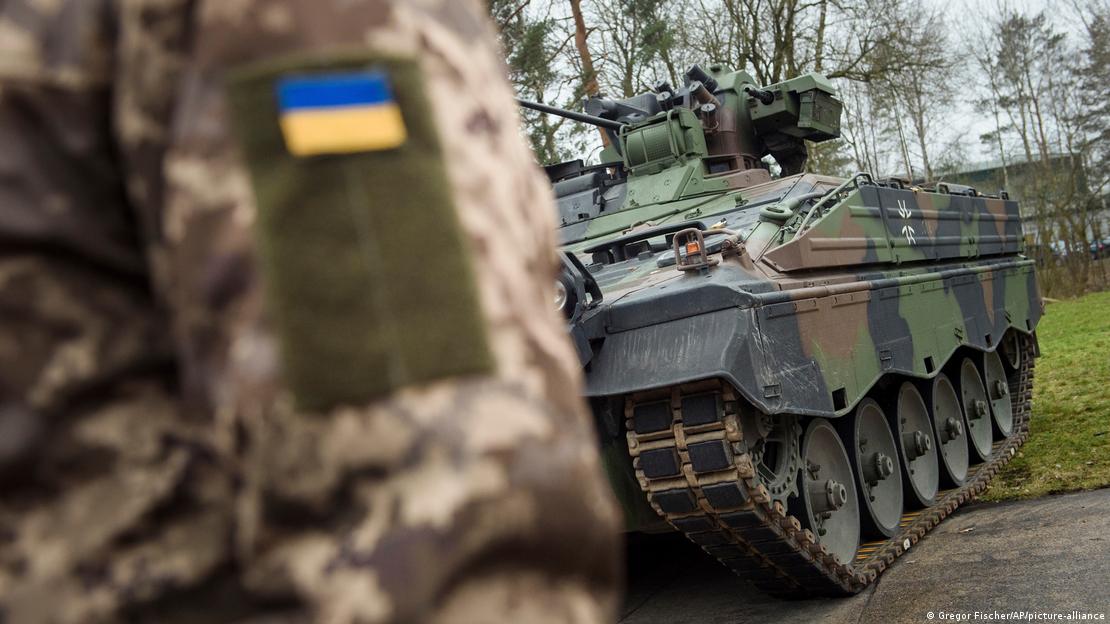 Alman ordusuna ait Marder tipi bir zırhlı aracın önünde duran Ukraynalı bir asker