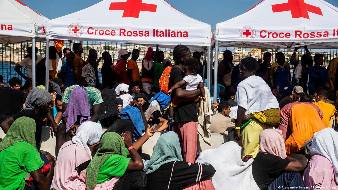 İtalya'nın Lampedusa adasına gelen sığınmacılar kayıtlarının yapılması için bekliyor. 